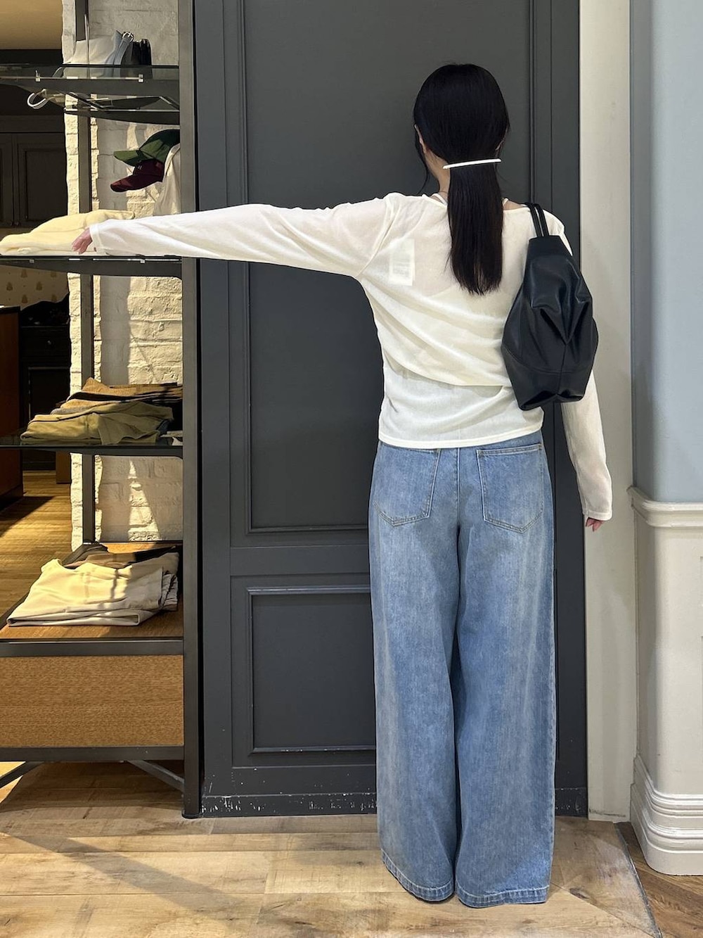 ブラック系のショルダーバッグ、ブルー系のデニムパンツ、ホワイト系のTシャツ/カットソーを着用したレディースの秋コーディネートの3枚目の写真