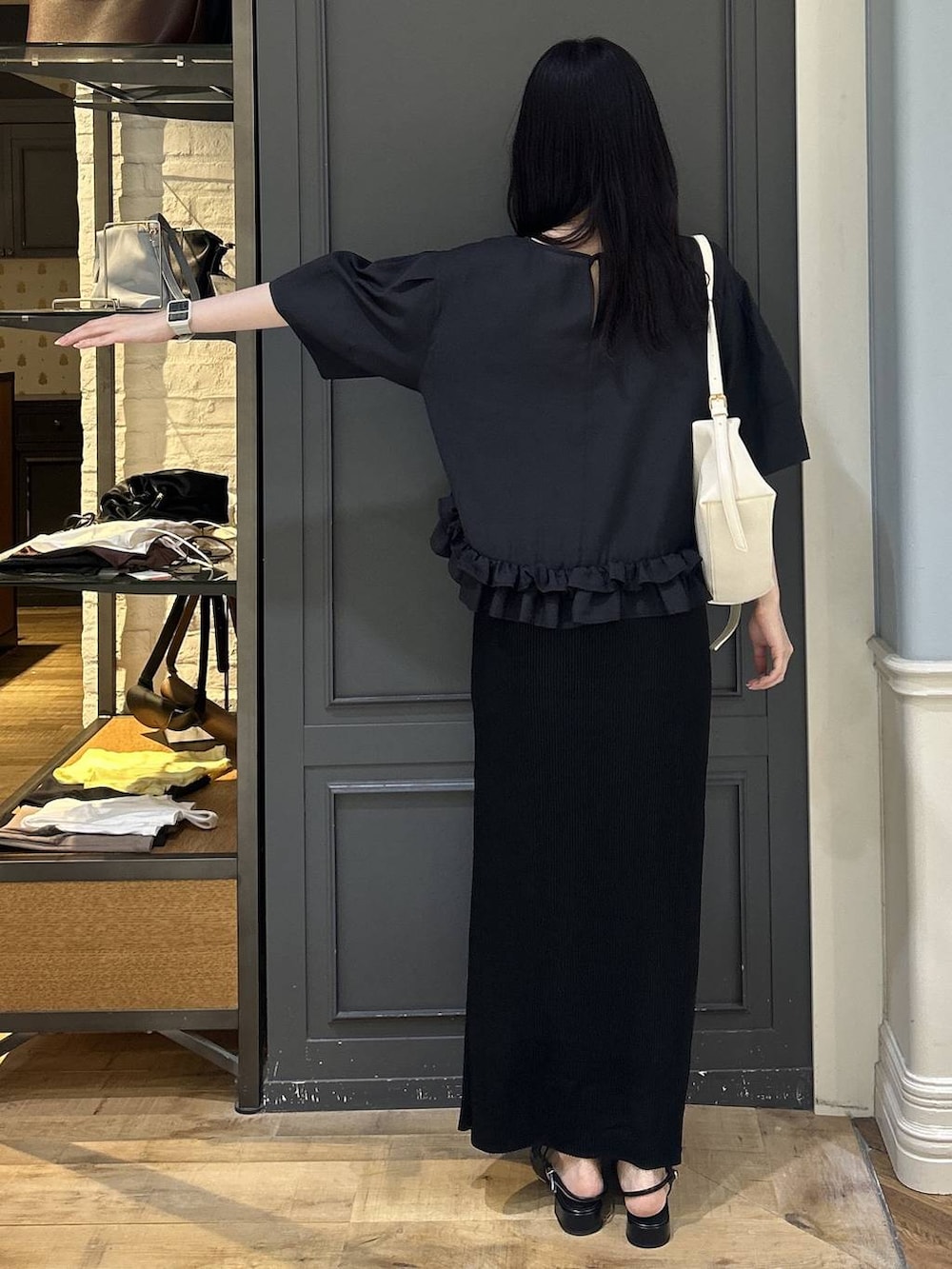 ホワイト系のショルダーバッグ、ブラック系のスカート、ブラック系のパンプスを着用したレディースの夏コーディネートの3枚目の写真