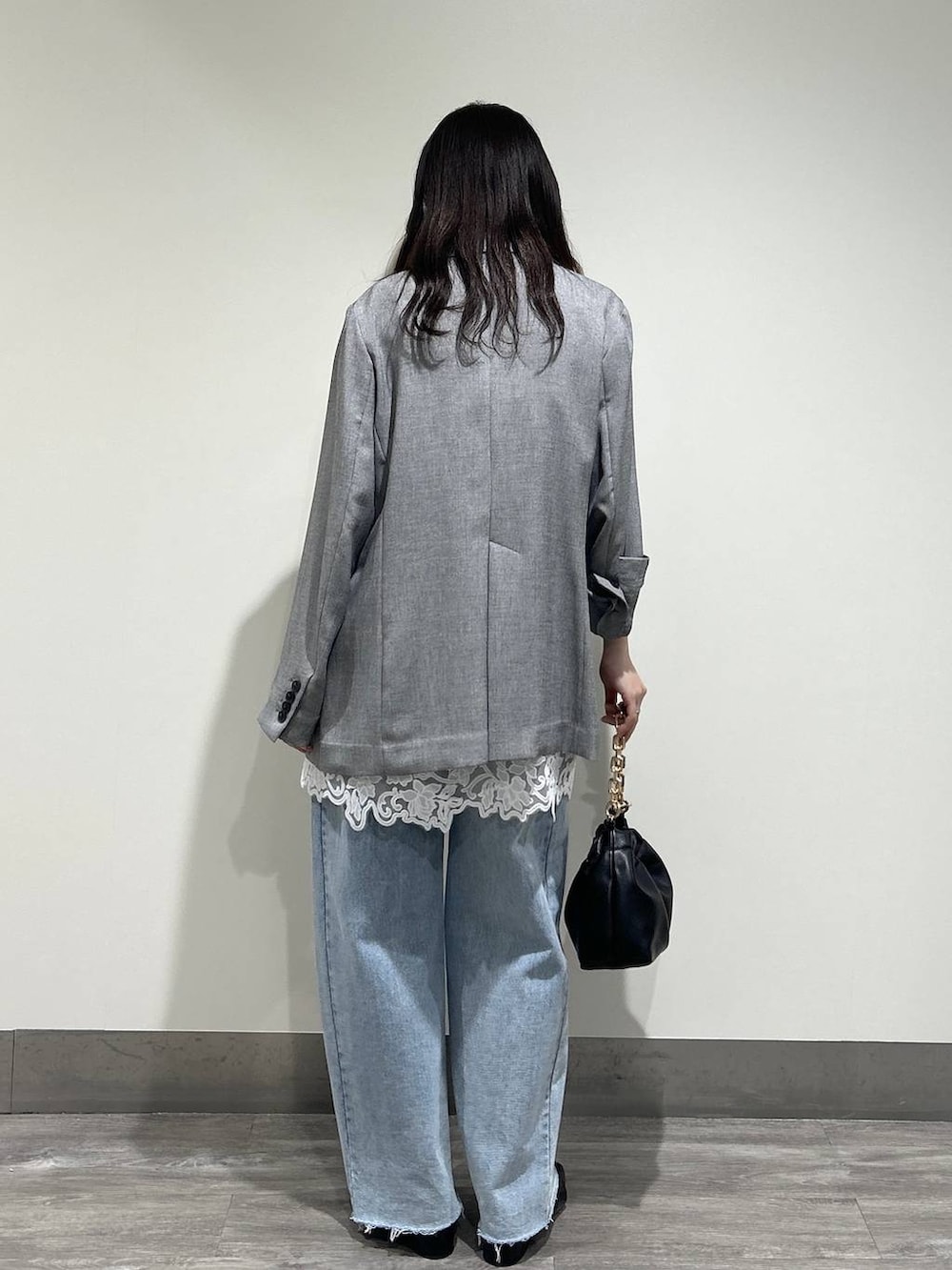 ブルー系のデニムパンツ、ホワイト系のキャミソール、ブラック系のノーカラージャケットを着用したレディースの春コーディネートの3枚目の写真