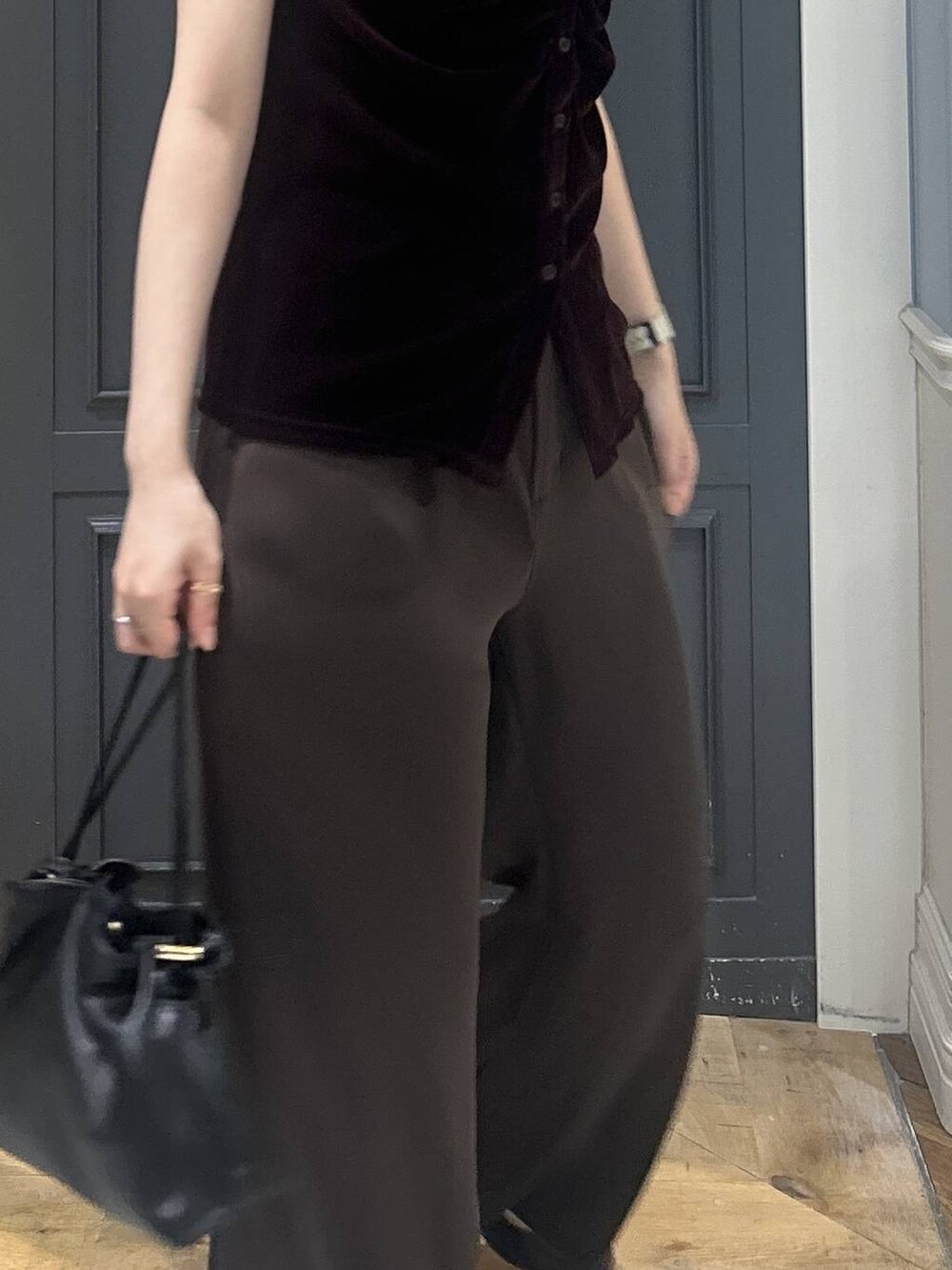 ブラック系のショルダーバッグ、ブラウン系のスラックス、ブラウン系のTシャツ/カットソーを着用したレディースの夏コーディネートの4枚目の写真