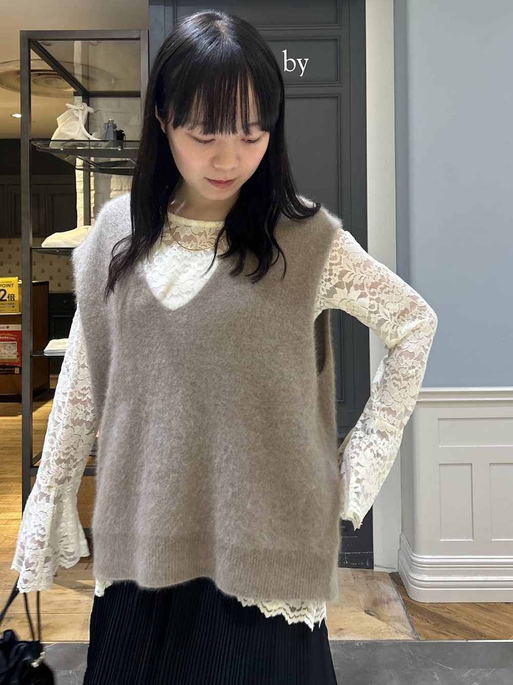 ブラック系のショルダーバッグ、ベージュ系のTシャツ/カットソー、ブラック系のスカートを着用したレディースの秋コーディネートの5枚目の写真