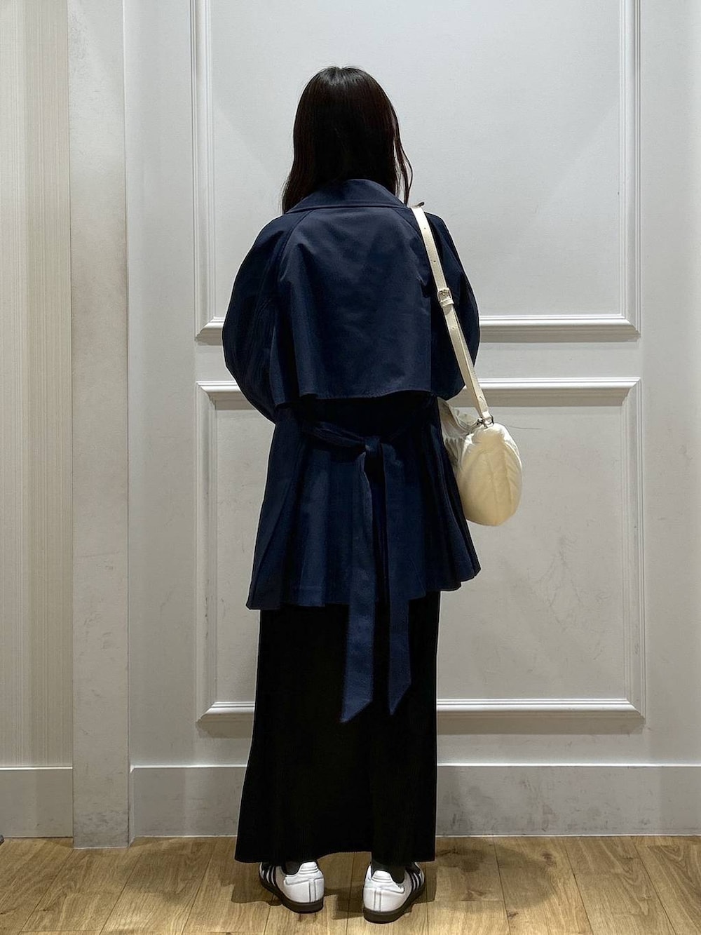 ブラック系のスカート、ホワイト系のTシャツ/カットソー、ブルー系のトレンチコートを着用したレディースの春コーディネートの3枚目の写真