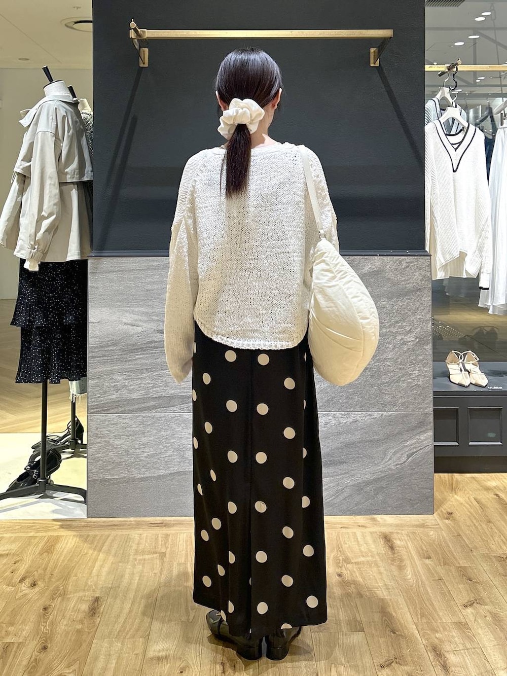 ブラック系のワンピース、ホワイト系のカーディガン/ボレロを着用したレディースの春コーディネートの3枚目の写真