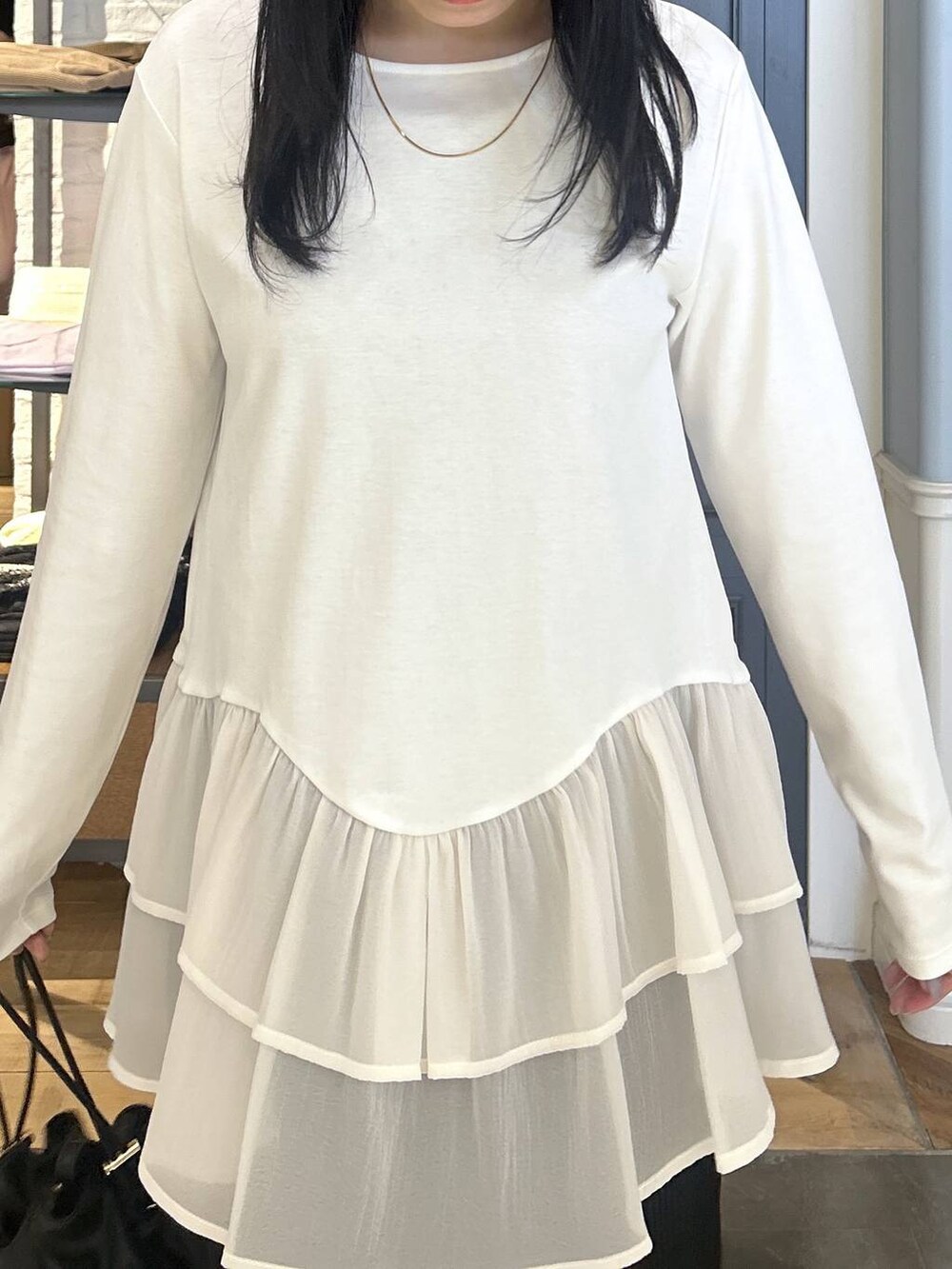 ブラック系のショルダーバッグ、ブラック系のローファー、ベージュ系のTシャツ/カットソーを着用したレディースの秋コーディネートの5枚目の写真
