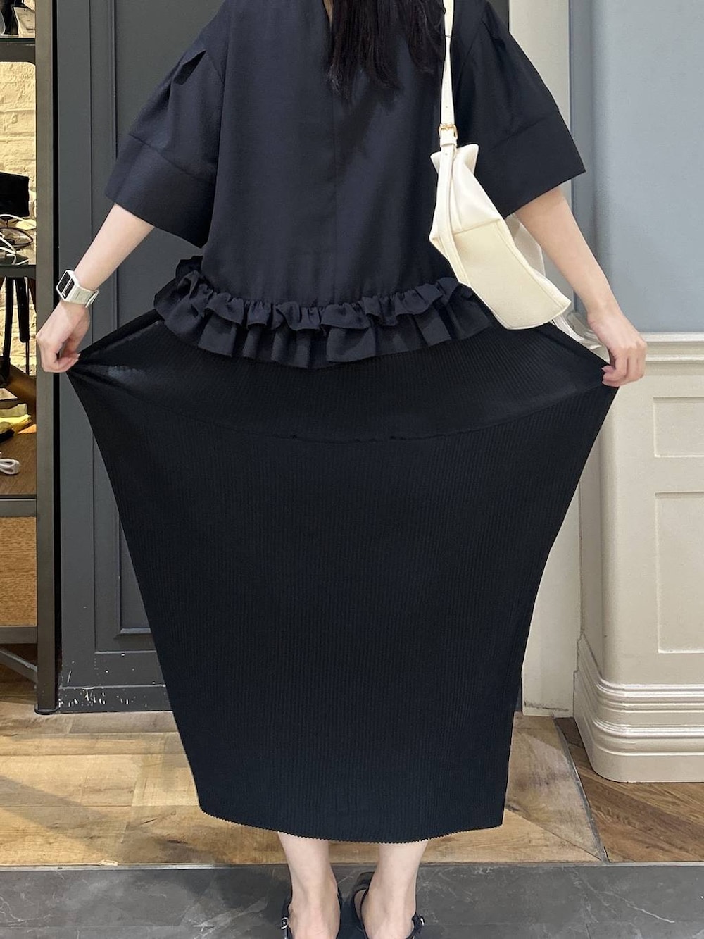 ホワイト系のショルダーバッグ、ブラック系のスカート、ブラック系のパンプスを着用したレディースの夏コーディネートの4枚目の写真