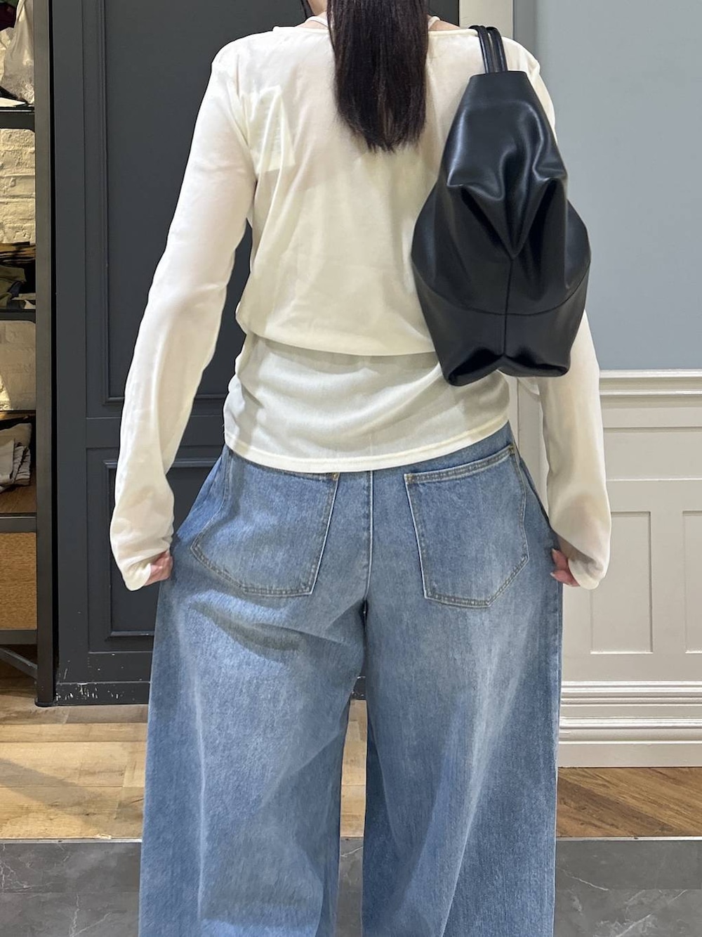 ブラック系のショルダーバッグ、ブルー系のデニムパンツ、ホワイト系のTシャツ/カットソーを着用したレディースの秋コーディネートの4枚目の写真