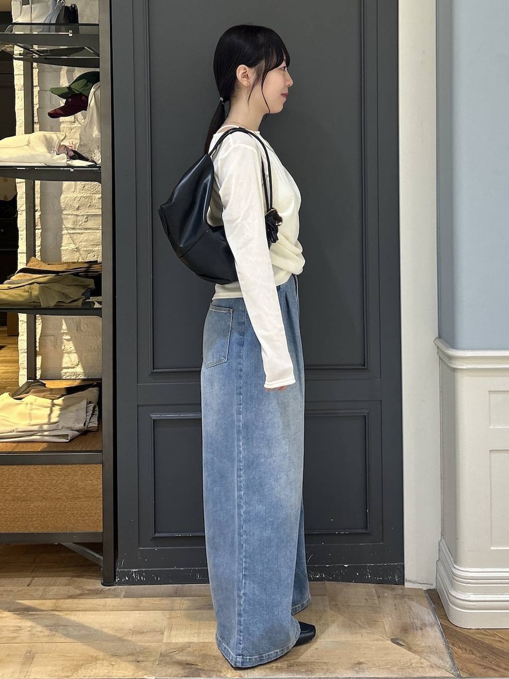 ブラック系のショルダーバッグ、ブルー系のデニムパンツ、ホワイト系のTシャツ/カットソーを着用したレディースの秋コーディネートの2枚目の写真