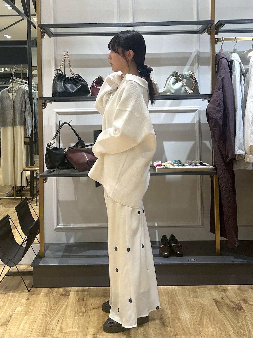 ホワイト系のニット/セーター、ブラック系のローファー、ホワイト系のTシャツ/カットソーを着用したレディースの冬コーディネートの2枚目の写真