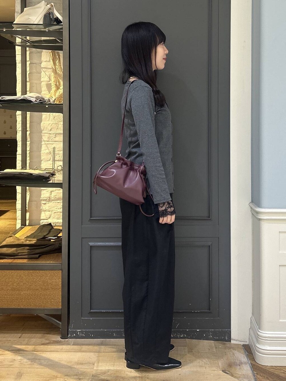 レッド系のショルダーバッグ、グレー系のTシャツ/カットソー、ブラック系のパンプスを着用したレディースの秋コーディネートの2枚目の写真