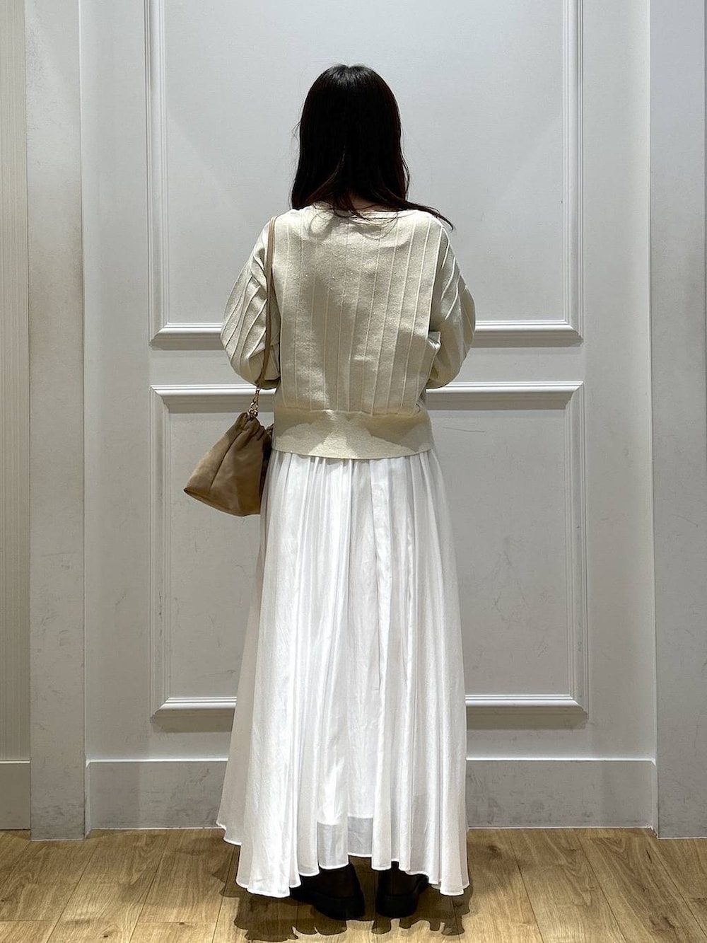 ベージュ系のカーディガン/ボレロ、ホワイト系のスカート、ブラウン系のローファーを着用したレディースの春コーディネートの3枚目の写真