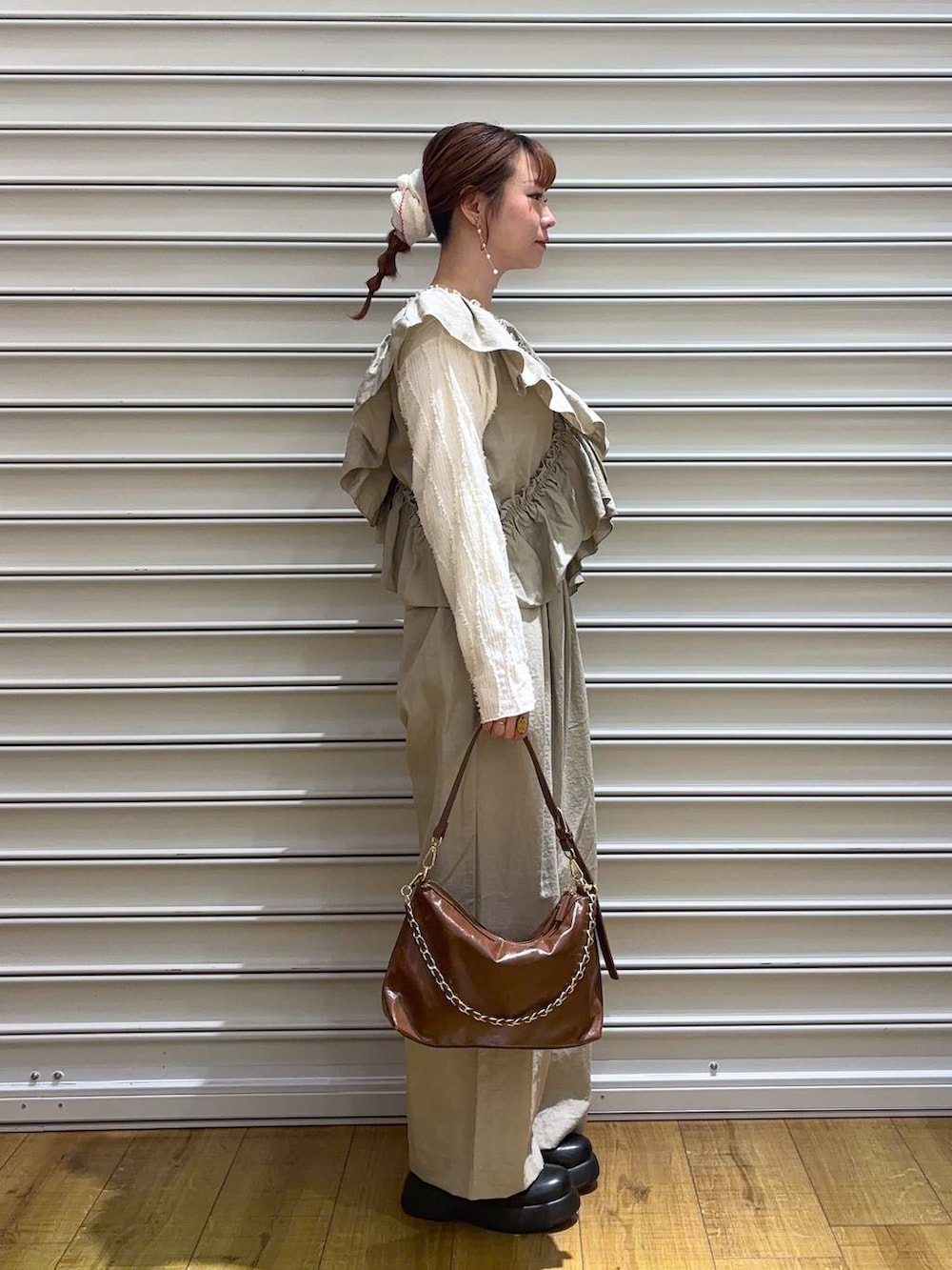 ベージュ系のTシャツ/カットソー、ブラウン系のショルダーバッグ、ブラック系のサンダルを着用したレディースの春コーディネートの2枚目の写真