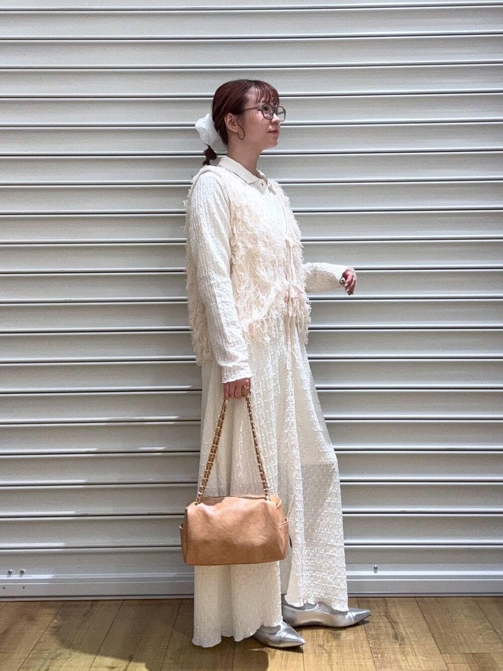 シルバー系のパンプス、ベージュ系のショルダーバッグ、ホワイト系のワンピースを着用したレディースの冬コーディネートの2枚目の写真