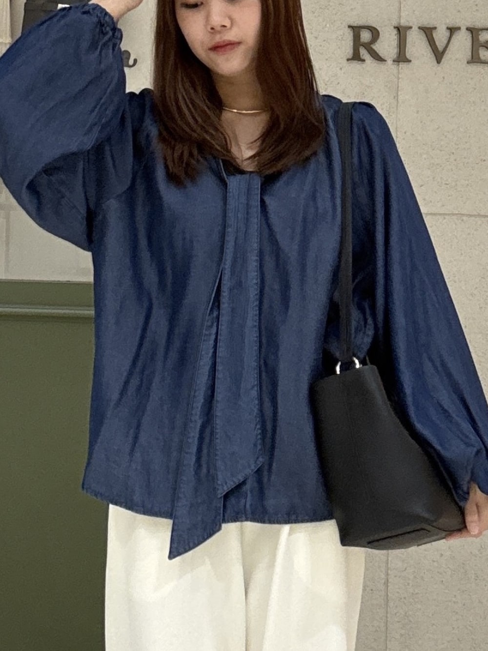 ブルー系のシャツ/ブラウス、ブラック系のトートバッグ、ホワイト系のその他パンツを着用したレディースの秋コーディネートの4枚目の写真