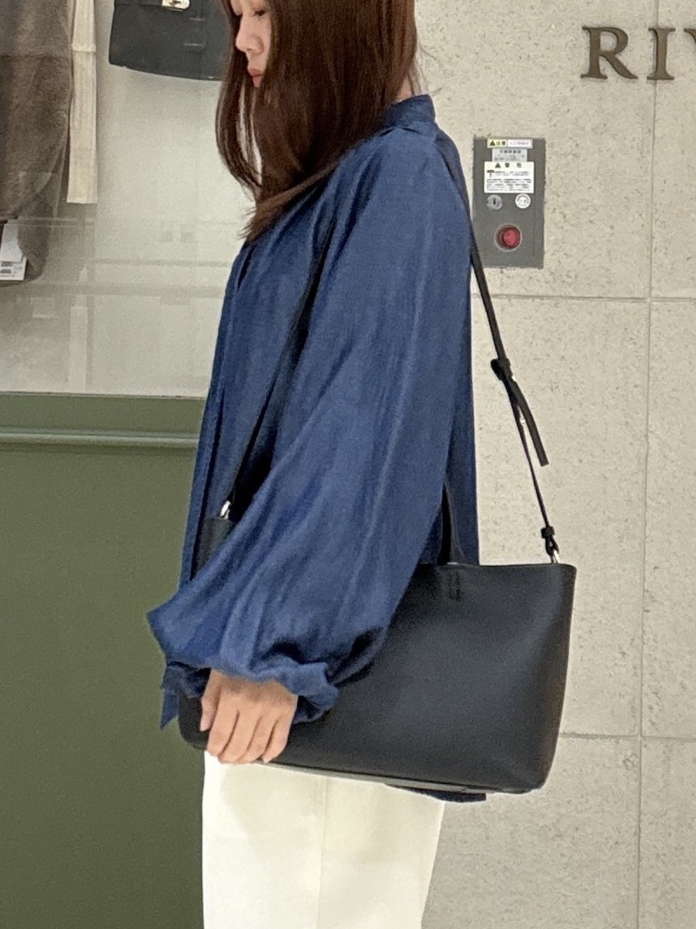 ブルー系のシャツ/ブラウス、ブラック系のトートバッグ、ホワイト系のその他パンツを着用したレディースの秋コーディネートの5枚目の写真
