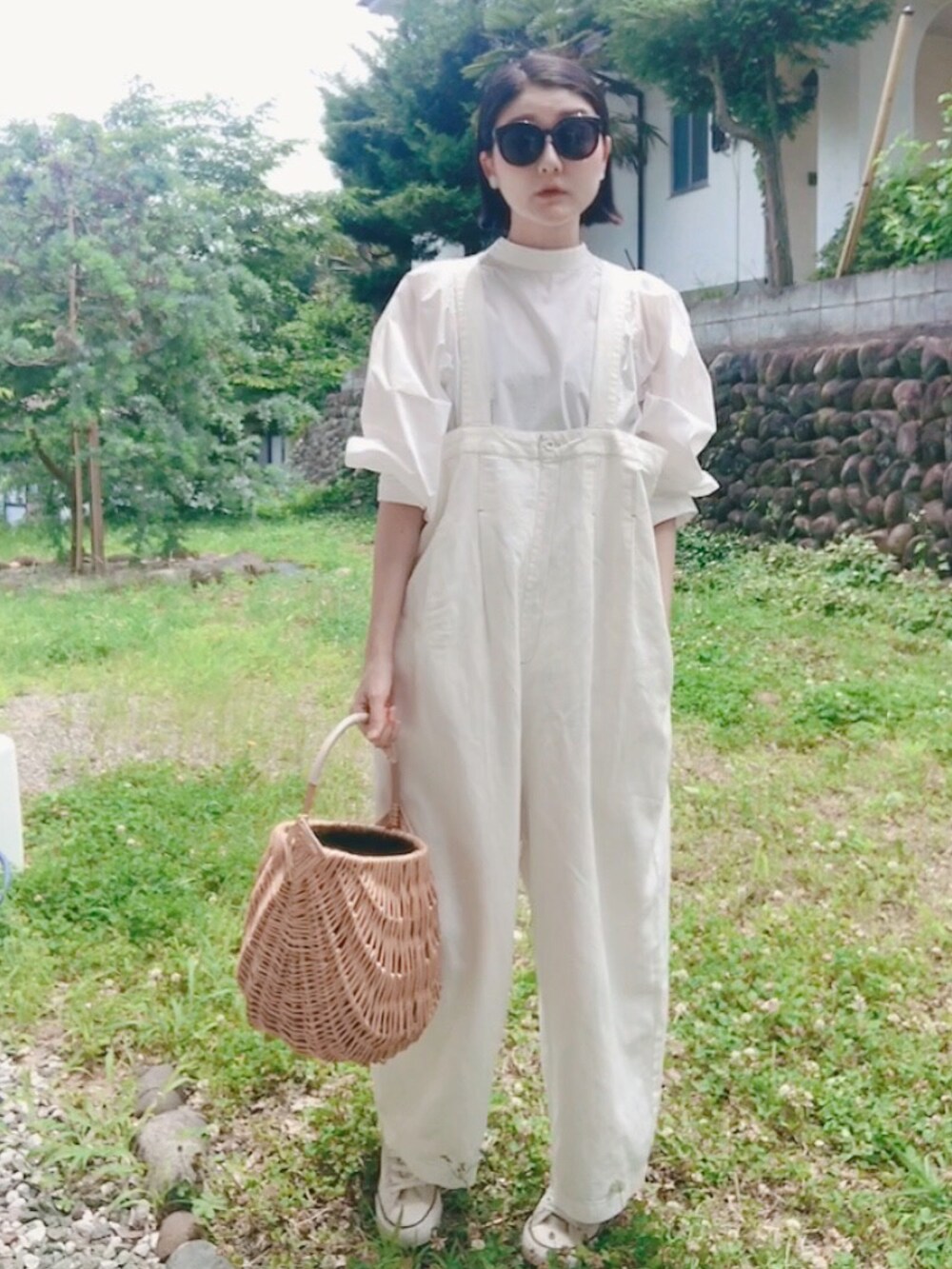 ホワイト系のシャツ/ブラウス、ベージュ系のかごバッグ、ブラック系のサングラスを着用したレディースの夏コーディネートの2枚目の写真