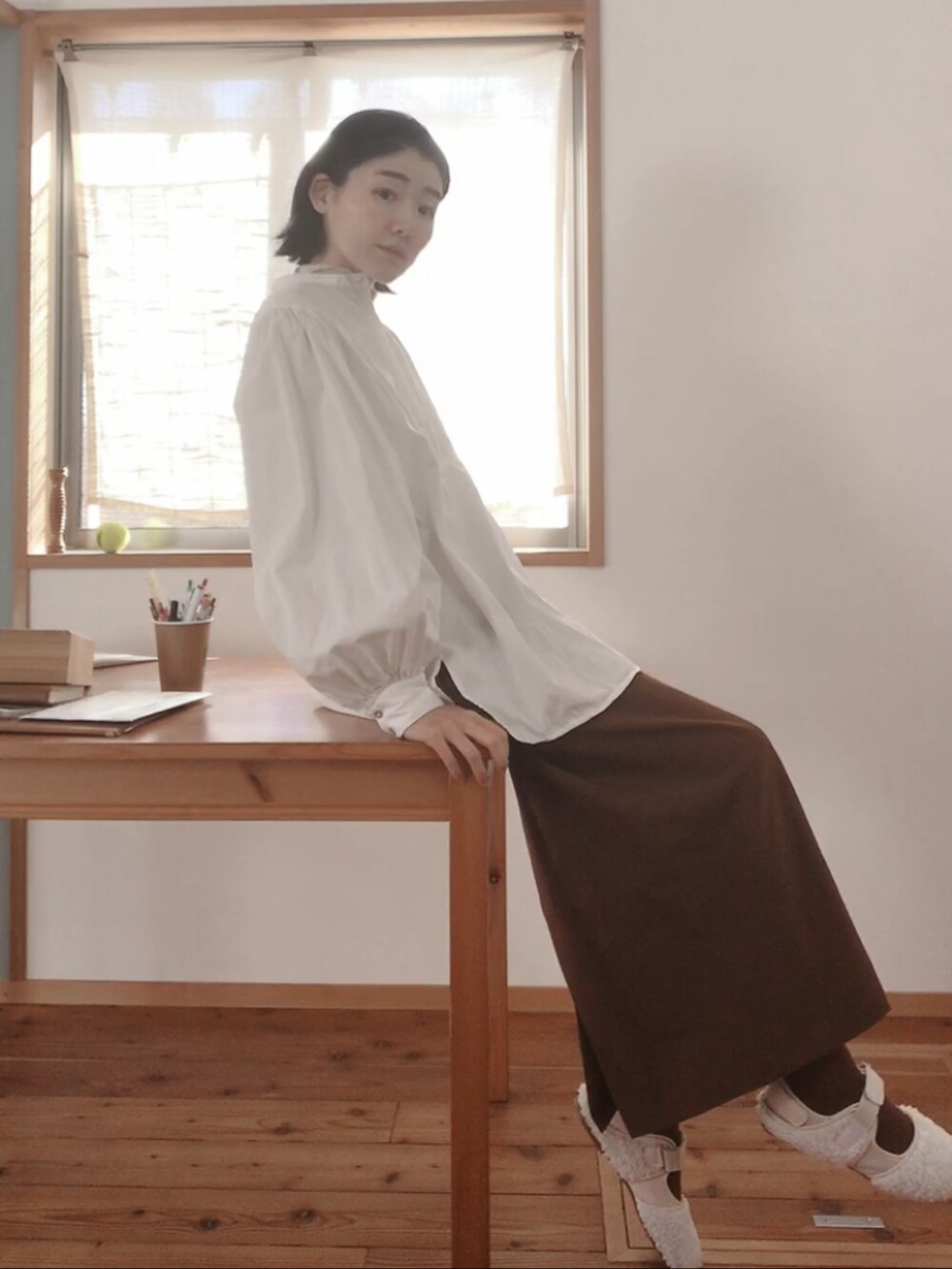 ブラウン系のスカート、ベージュ系のスニーカー、ホワイト系のシャツ/ブラウスを着用したレディースの春コーディネートの2枚目の写真