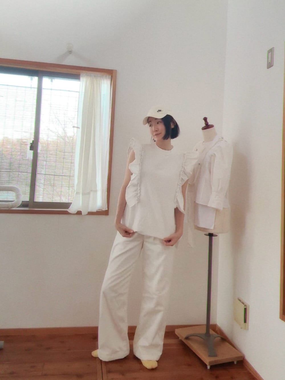 ホワイト系のTシャツ/カットソー、ホワイト系のチノパンツ、ホワイト系のキャップを着用したレディースの春コーディネートの2枚目の写真