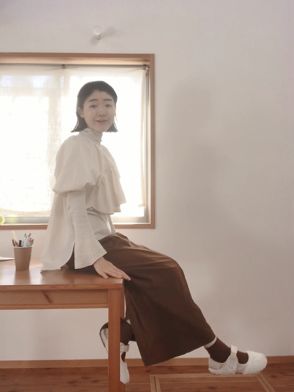 ブラウン系のスカート、ベージュ系のスニーカーを着用したレディースの春コーディネートの2枚目の写真