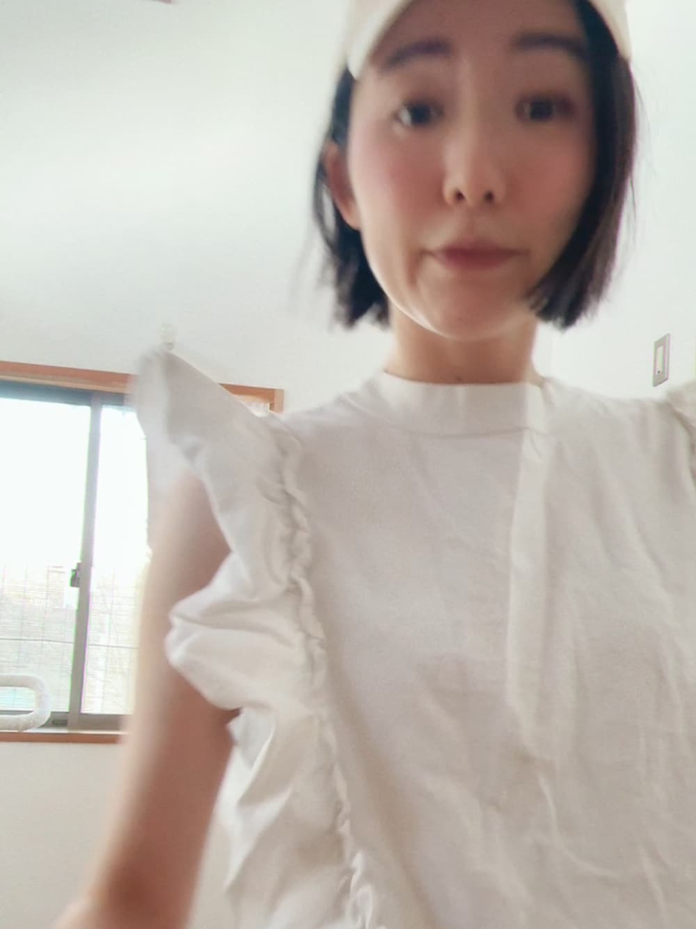 ホワイト系のTシャツ/カットソー、ホワイト系のチノパンツ、ホワイト系のキャップを着用したレディースの春コーディネートの3枚目の写真