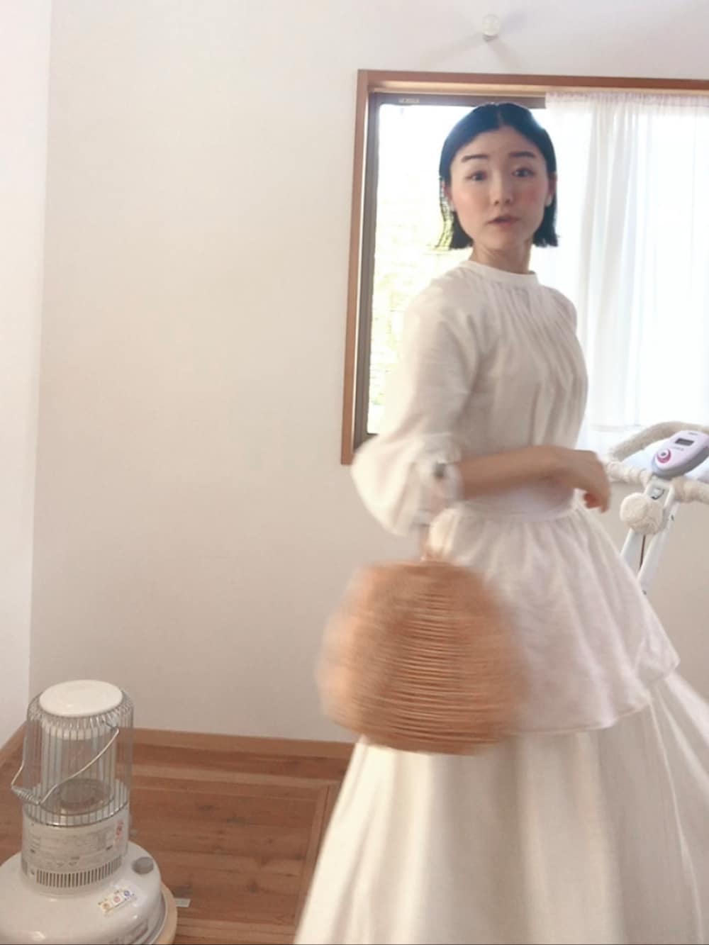 ベージュ系のかごバッグ、ホワイト系のスカート、ホワイト系のワンピースを着用したレディースの春コーディネートの3枚目の写真