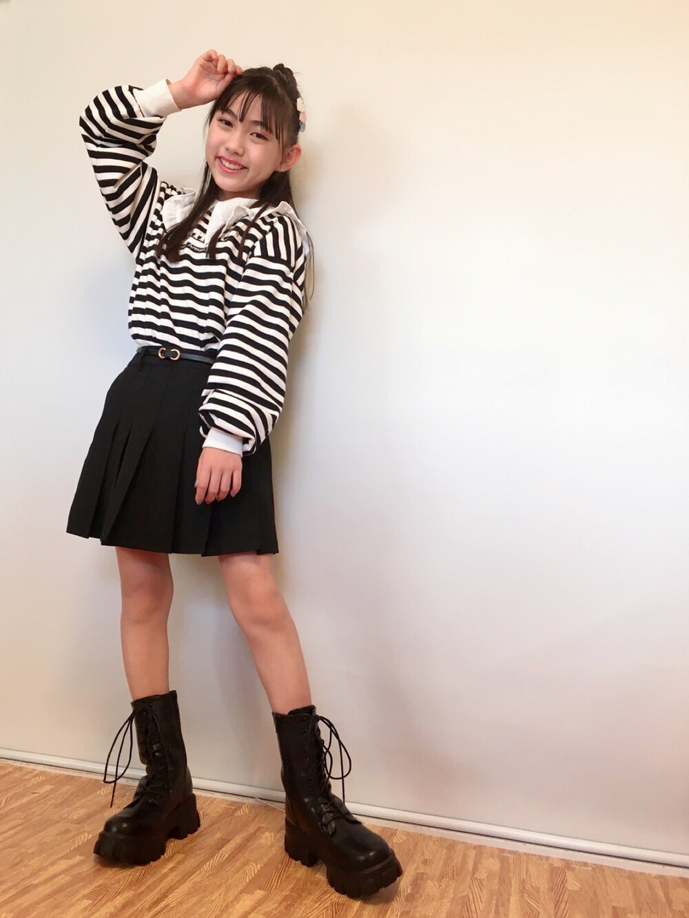 ブラック系のスカート、ホワイト系のシャツ/ブラウス、ブラック系のブーツを着用したキッズの秋コーディネートの2枚目の写真