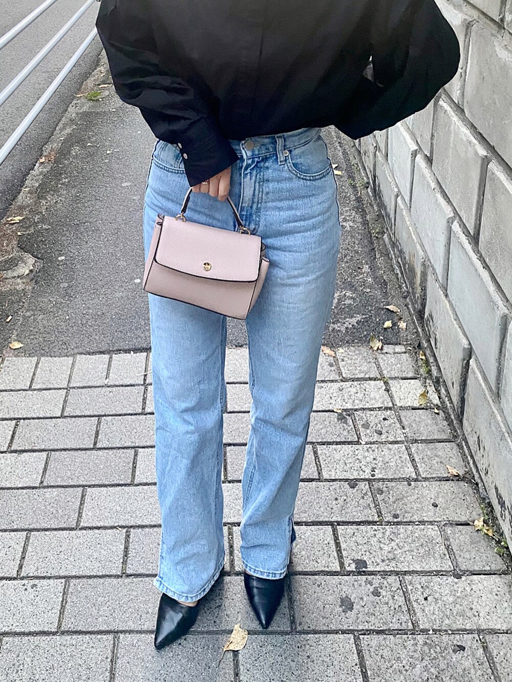 ブルー系のデニムパンツ、ブラック系のシャツ/ブラウス、ピンク系のバッグを着用したレディースの春コーディネートの2枚目の写真