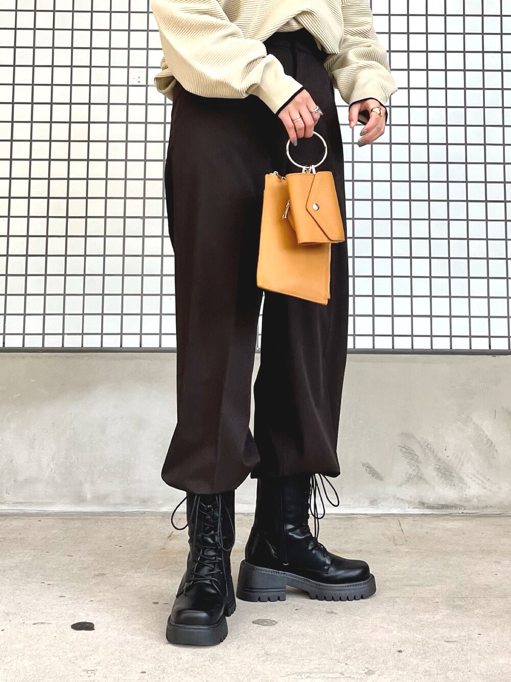 ホワイト系のニット/セーター、ブラウン系のパンツ、イエロー系のショルダーバッグを着用したレディースの秋コーディネートの3枚目の写真