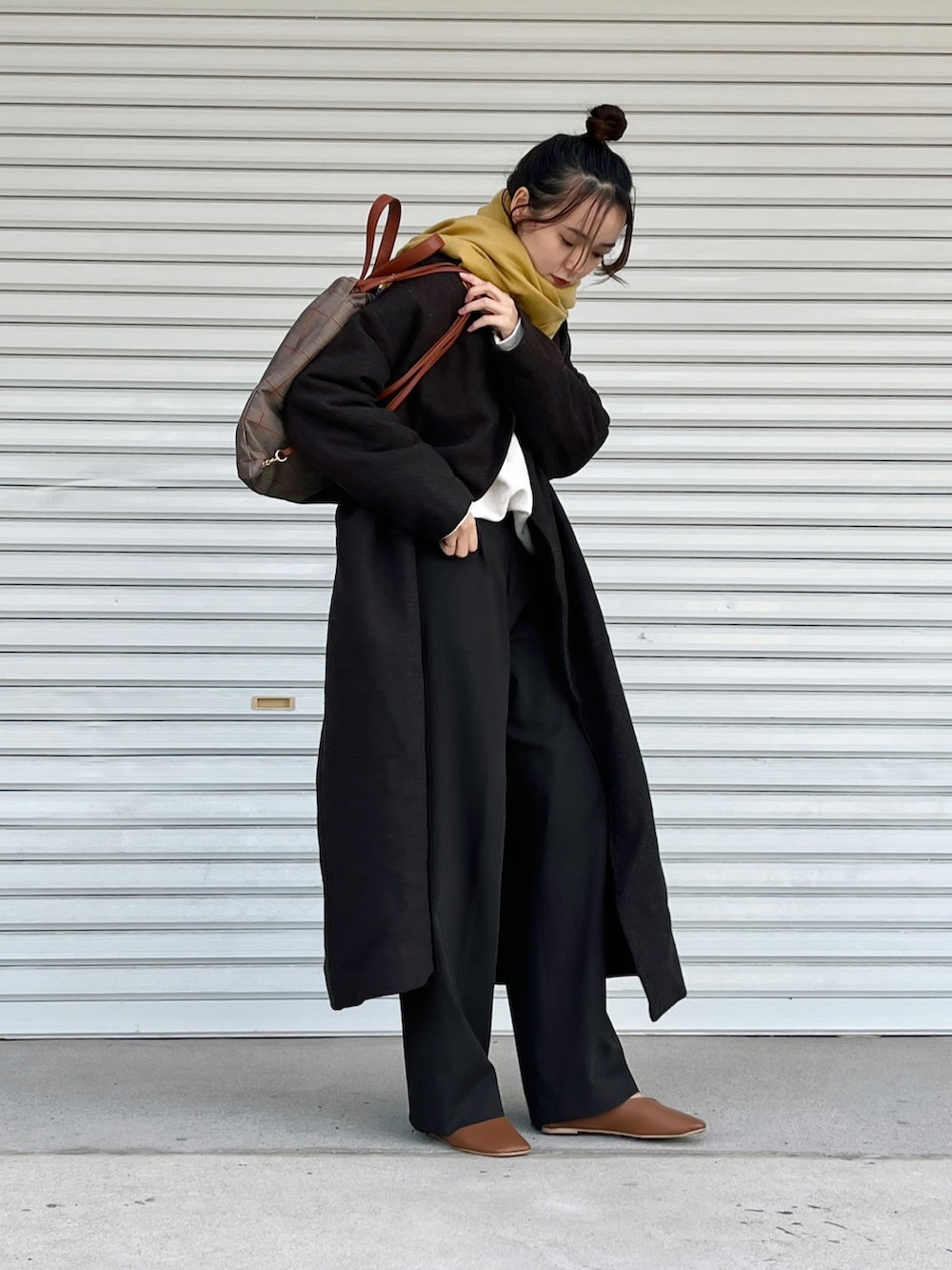 ブラウン系のパンプス、ブラウン系のパンツ、ホワイト系のトップスを着用したレディースの冬コーディネートの2枚目の写真