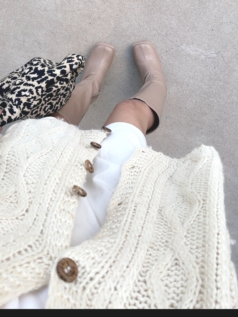 ベージュ系のトップス、ベージュ系のブーツ、シルバー系のネックレスを着用したレディースの冬コーディネートの4枚目の写真