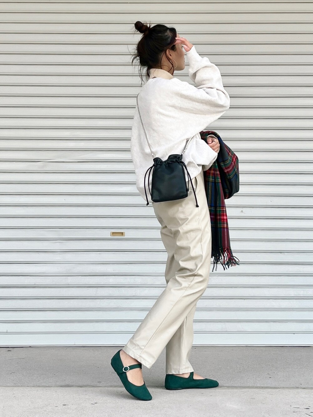 グリーン系のバレエシューズ、ブラック系のショルダーバッグ、ホワイト系のトップスを着用したレディースの冬コーディネートの3枚目の写真