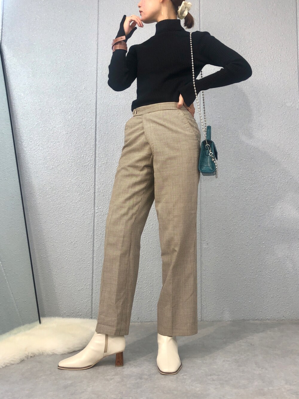 ブルー系のショルダーバッグ、ホワイト系のブーツを着用したレディースの秋コーディネートの2枚目の写真