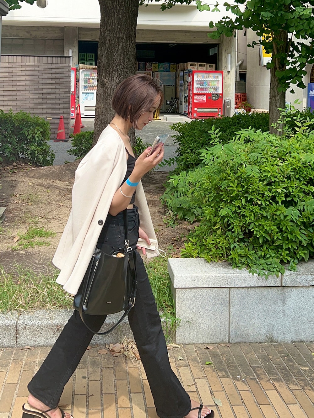 ブラック系のサンダル、ブラック系のバッグ、ブルー系のデニムパンツを着用したレディースの夏コーディネートの2枚目の写真