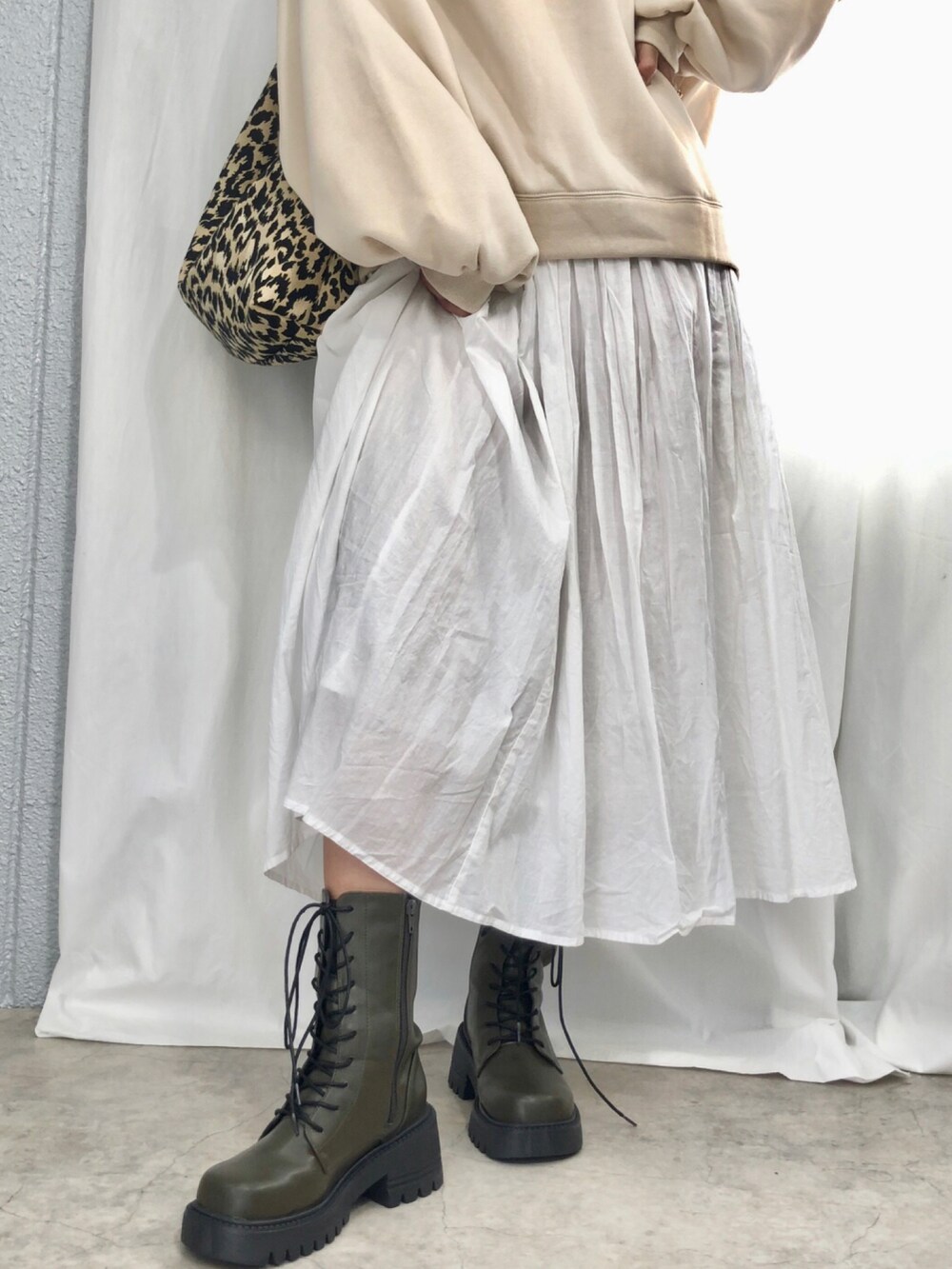 グリーン系のブーツを着用したレディースの秋コーディネートの2枚目の写真