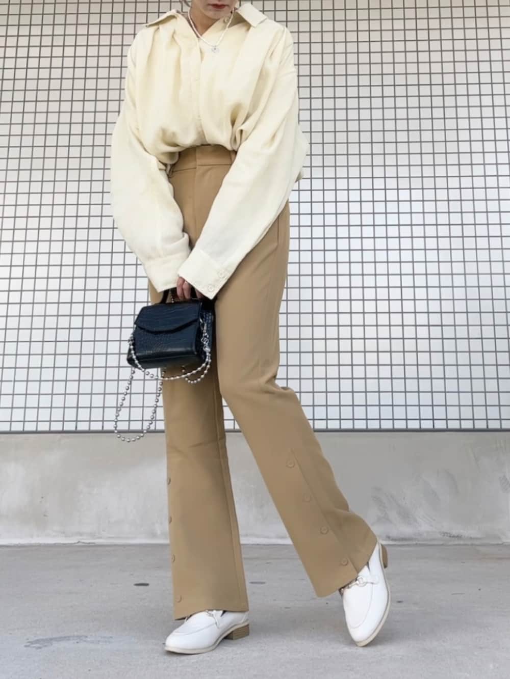 ブラック系のショルダーバッグ、ホワイト系のシャツ/ブラウス、ホワイト系のローファーを着用したレディースの冬コーディネートの2枚目の写真