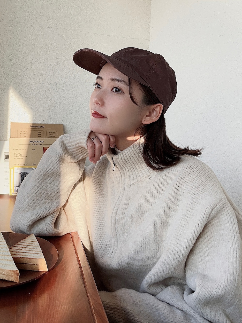 ブラウン系のチェスターコート、ブラウン系のパンツ、その他のトートバッグを着用したレディースの冬コーディネートの4枚目の写真