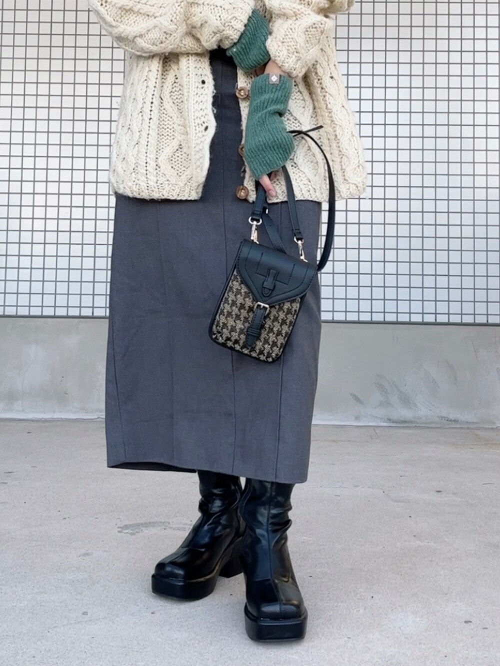 ベージュ系のトップス、グレー系のワンピース/ドレス、ブラック系のブーツを着用したレディースの冬コーディネートの2枚目の写真