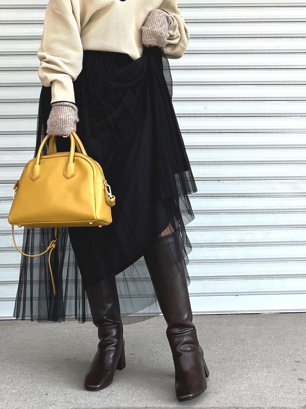 ホワイト系のニット/セーター、ブラック系のスカート、ブラウン系のブーツを着用したレディースの秋コーディネートの4枚目の写真