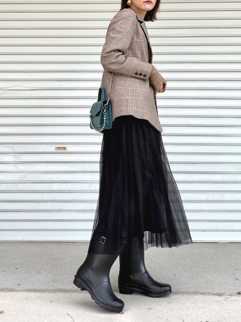 その他のテーラードジャケット、ブラック系のスカート、ブラック系のレインシューズを着用したレディースの秋コーディネートの2枚目の写真