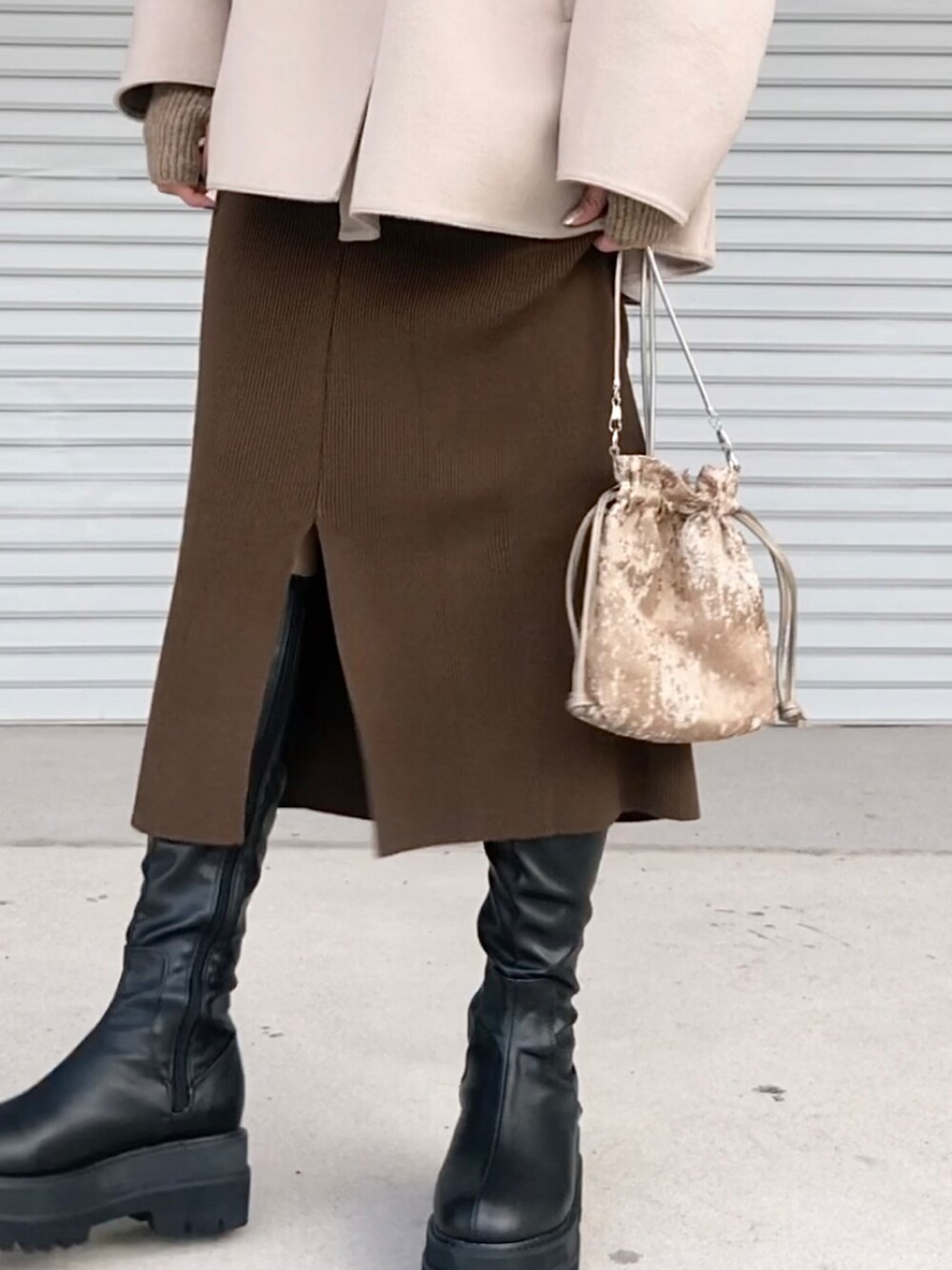 ホワイト系のニット/セーター、ベージュ系のジャケット/アウター、ブラック系のブーツを着用したレディースの秋コーディネートの4枚目の写真