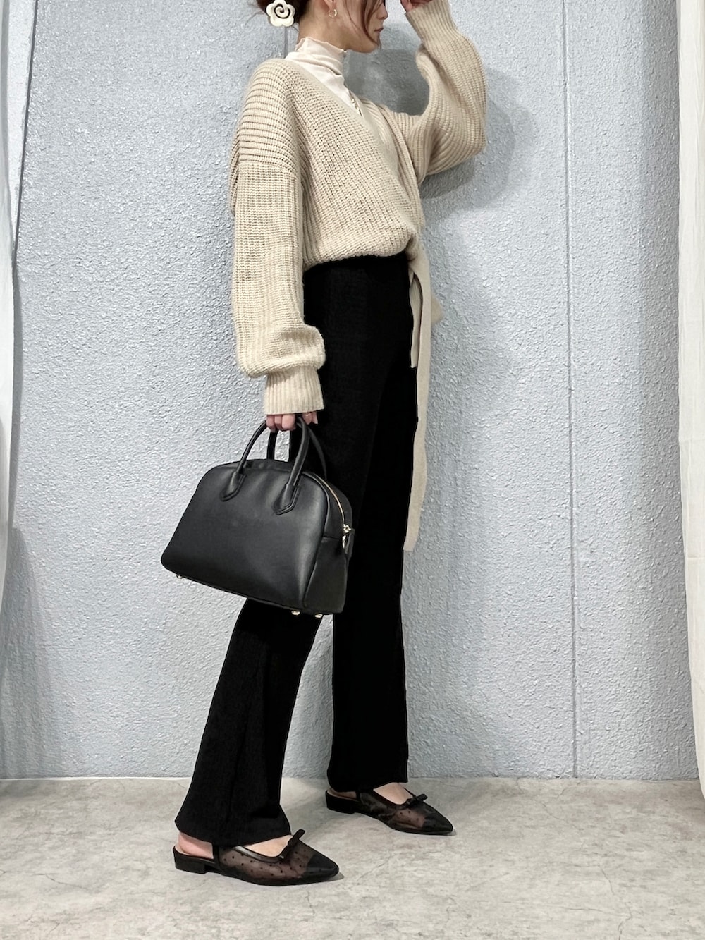 ベージュ系のカーディガン/ボレロ、ブラック系のパンツ、ブラック系のショルダーバッグを着用したレディースの春コーディネートの2枚目の写真