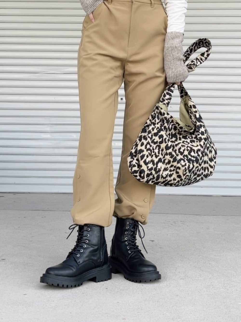 ブラック系のブーツ、ブラウン系のアームカバー、シルバー系のネックレスを着用したレディースの冬コーディネートの2枚目の写真