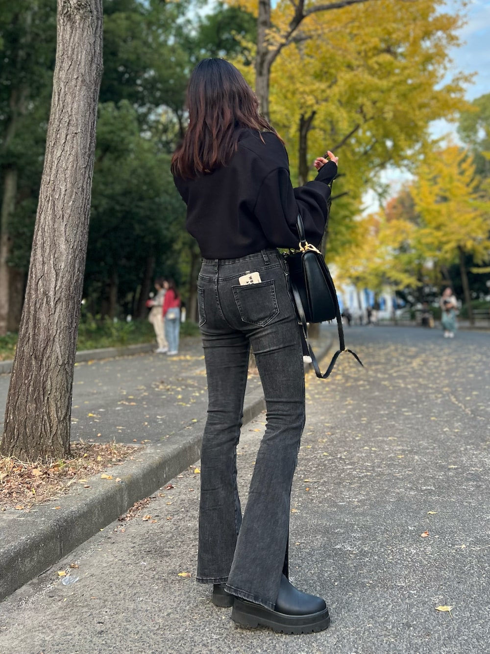 ブラック系のブーツ、ブラック系のデニムパンツ、ブラック系のニット/セーターを着用したレディースの冬コーディネートの2枚目の写真