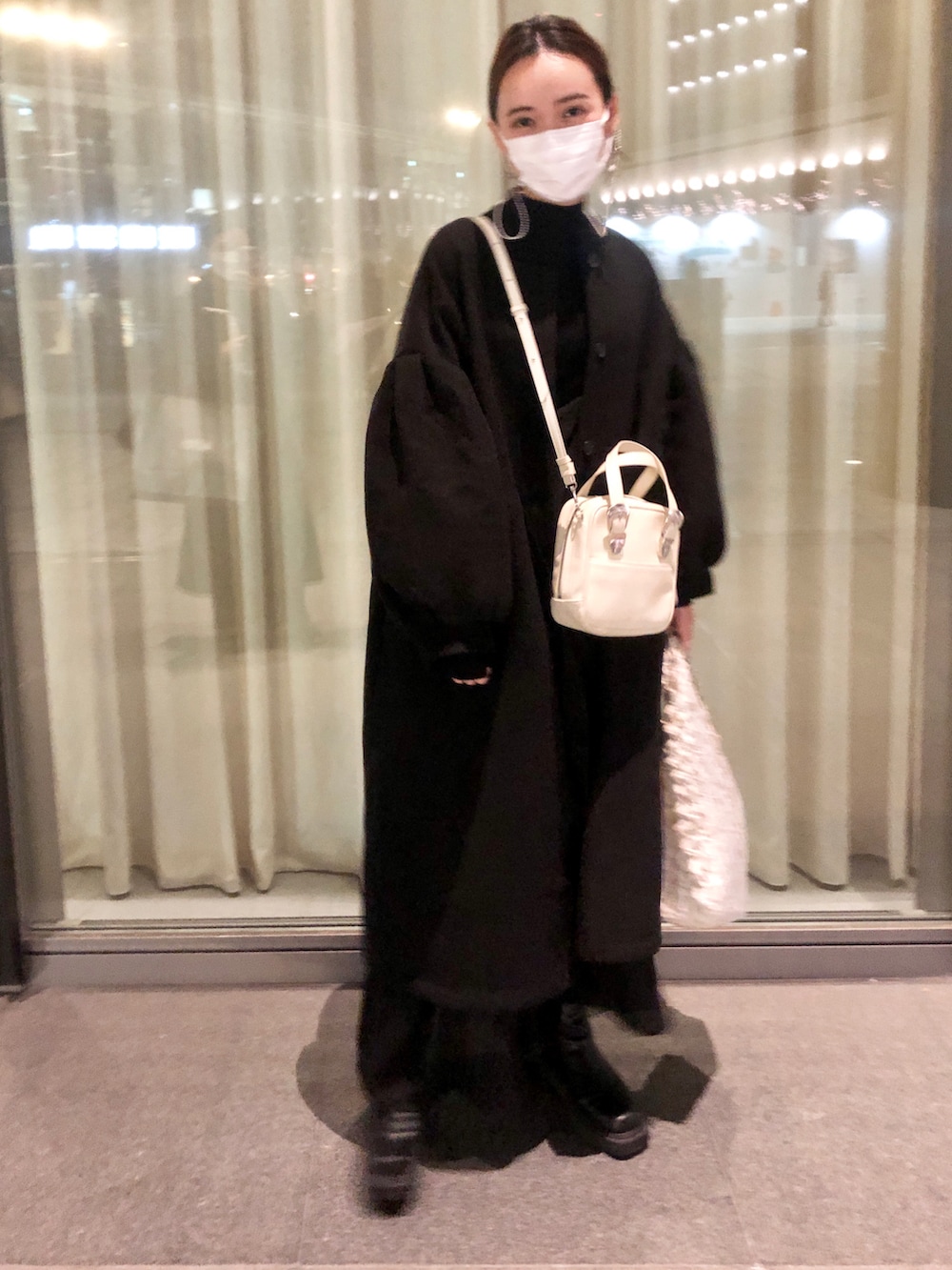 ブラック系のその他アウター、ブラック系のニット/セーター、ブラック系のワンピースを着用したレディースの冬コーディネートの2枚目の写真