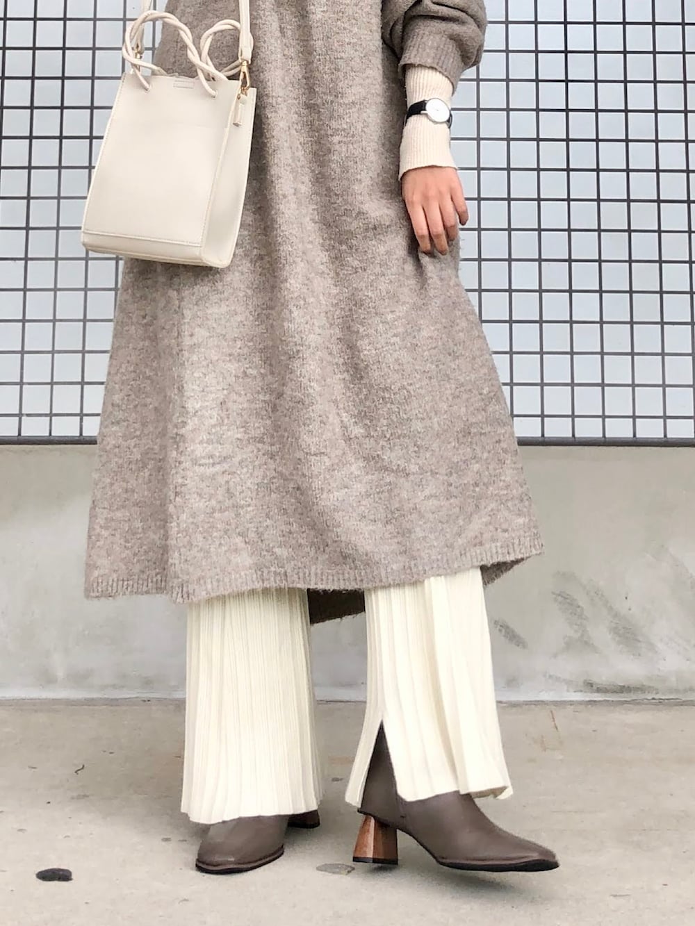 ホワイト系のその他パンツ、ベージュ系のブーツ、ベージュ系のショルダーバッグを着用したレディースの秋コーディネートの3枚目の写真