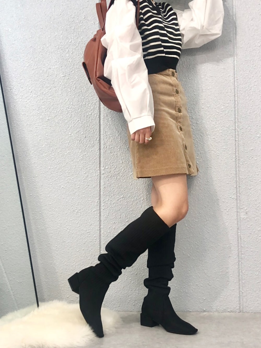 ブラック系のブーツ、ゴールド系のネックレス、その他のリングを着用したレディースの秋コーディネートの3枚目の写真