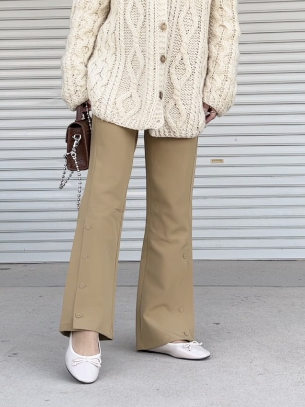 ベージュ系のトップス、ブラウン系のショルダーバッグ、ベージュ系のバレエシューズを着用したレディースの冬コーディネートの2枚目の写真