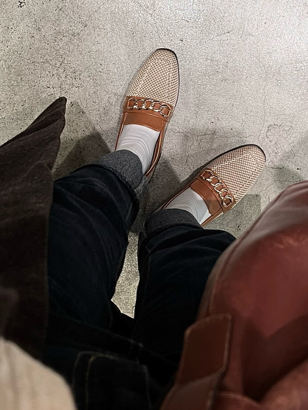 ベージュ系のトップス、ブラウン系のチェスターコート、ブルー系のデニムパンツを着用したレディースの冬コーディネートの3枚目の写真