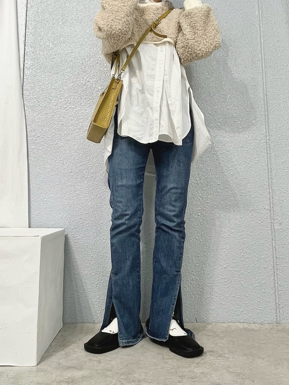 ブルー系のデニムパンツ、ホワイト系のシャツ/ブラウス、ベージュ系のトップスを着用したレディースの冬コーディネートの2枚目の写真