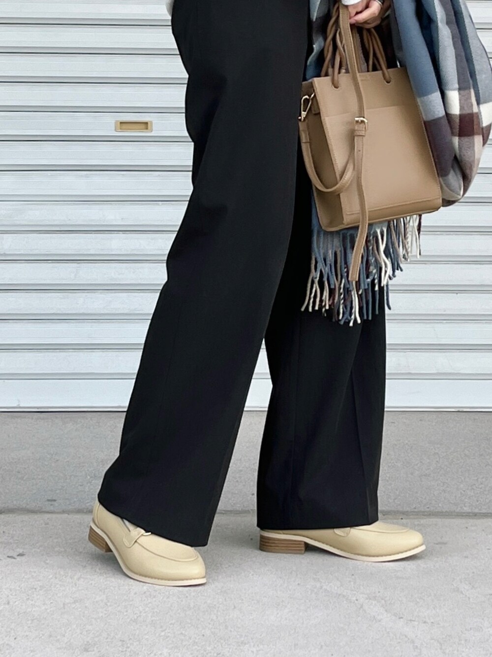 ブラウン系のパンツ、ホワイト系のトップス、ブラウン系のショルダーバッグを着用したレディースの冬コーディネートの4枚目の写真