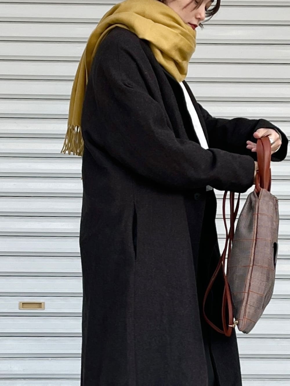 ブラウン系のパンプス、ブラウン系のパンツ、ホワイト系のトップスを着用したレディースの冬コーディネートの3枚目の写真